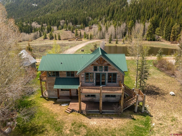 536 Journeys End Rd, Crested Butte, CO 81224 - rear view of property featuring a forest view, a deck with water view, metal roof, and stairway