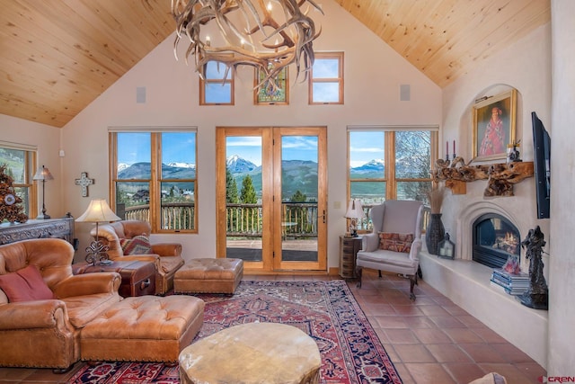 536 Journeys End Rd, Crested Butte, CO 81224 - tiled living area with high vaulted ceiling, a chandelier, wood ceiling, and a glass covered fireplace