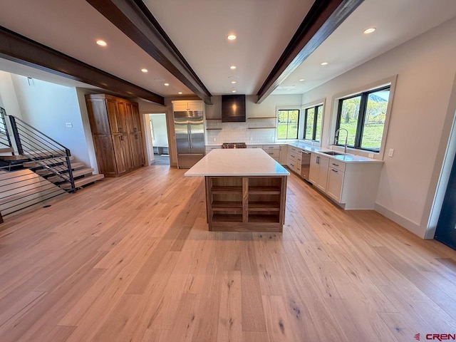 470 Meadow Dr, Crested Butte, CO 81224 - kitchen featuring appliances with stainless steel finishes, beam ceiling, light wood finished floors, tasteful backsplash, and a sink