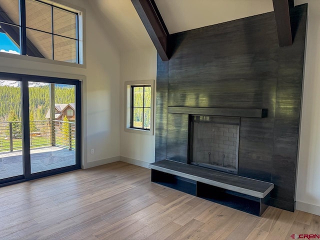 470 Meadow Dr, Crested Butte, CO 81224 - unfurnished living room with high vaulted ceiling, baseboards, healthy amount of natural light, wood finished floors, and a large fireplace