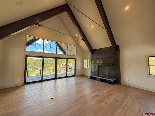 470 Meadow Dr, Crested Butte, CO 81224 - unfurnished living room with high vaulted ceiling, baseboards, beamed ceiling, a large fireplace, and plenty of natural light