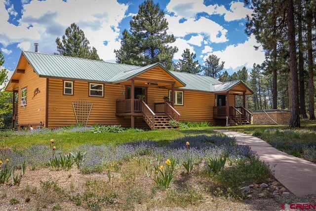 30 Stagecoach Rd, Bayfield, CO 81122 - rustic home with faux log siding, covered porch, stairs, and metal roof