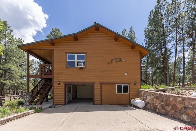 30 Stagecoach Rd, Bayfield, CO 81122 - view of home's exterior with concrete driveway, an attached garage, stairway, log veneer siding, and cooling unit