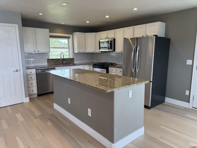 445 Saddle Cir, Pagosa Springs, CO 81147 - kitchen with appliances with stainless steel finishes, light wood-type flooring, a sink, tasteful backsplash, and recessed lighting