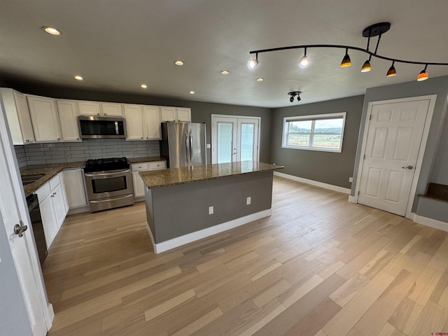 445 Saddle Cir, Pagosa Springs, CO 81147 - kitchen with stainless steel appliances, a kitchen island, light wood finished floors, baseboards, and recessed lighting