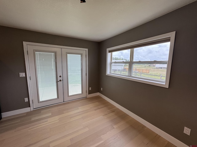 445 Saddle Cir, Pagosa Springs, CO 81147 - unfurnished room featuring french doors, light wood-style floors, and baseboards
