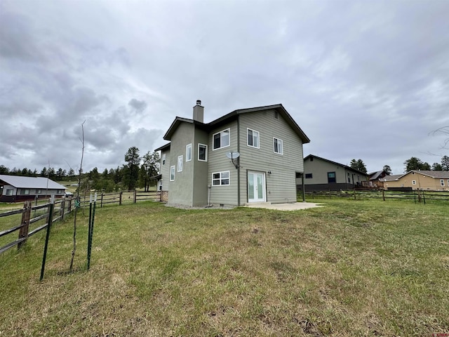 445 Saddle Cir, Pagosa Springs, CO 81147 - back of property with a chimney, french doors, and a patio area