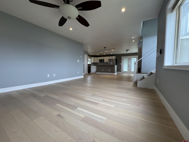 445 Saddle Cir, Pagosa Springs, CO 81147 - unfurnished living room with stairs, light wood finished floors, a ceiling fan, baseboards, and recessed lighting