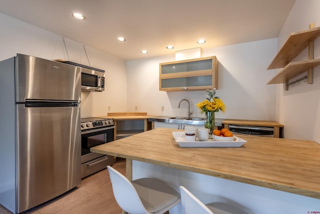 123 Boulders Way, Mountain Village, CO 81435 - kitchen featuring stainless steel appliances, wooden counters, a kitchen bar, recessed lighting, and glass insert cabinets