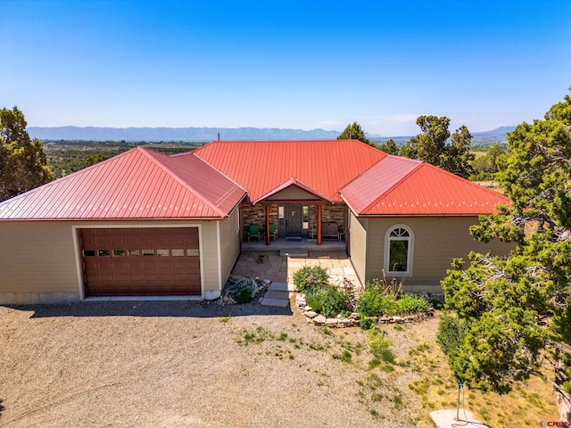 24180 Rd V.4, Dolores, CO 81323 - view of front of house with a garage, metal roof, a mountain view, and a porch