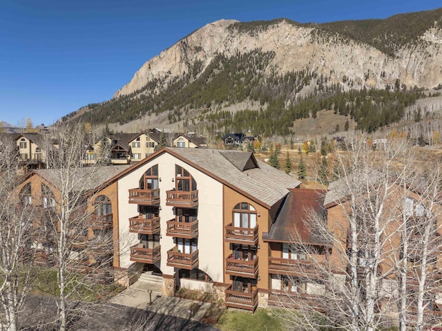 350 Country Club Dr Unit 308A, Crested Butte, CO 81224 - rear view of house with a balcony, a shingled roof, and a mountain view