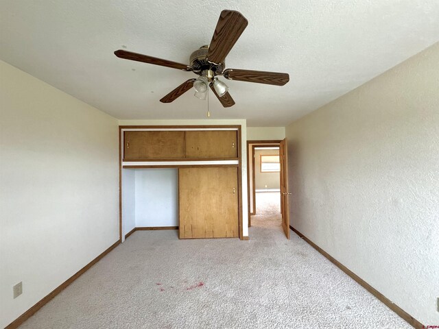 6645 Gaumer Ln, Alamosa, CO 81101 - unfurnished bedroom featuring light carpet, baseboards, a closet, ceiling fan, and a textured wall