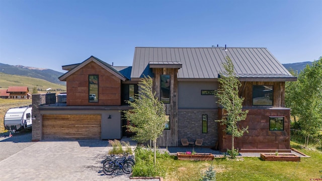 470 White Stallion Cir, Crested Butte, CO 81224 - modern home with a standing seam roof, stucco siding, a garage, a mountain view, and decorative driveway