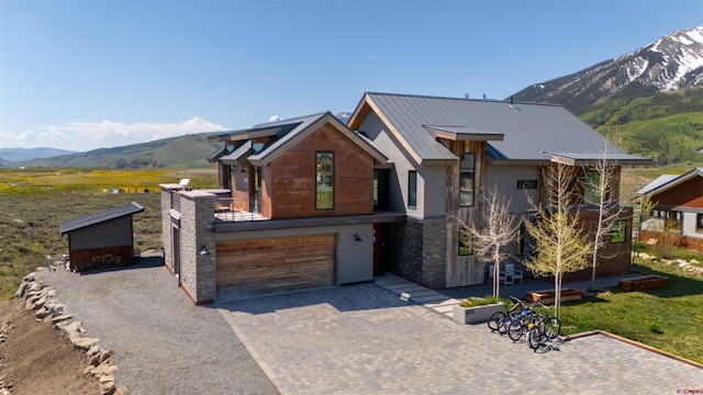 470 White Stallion Cir, Crested Butte, CO 81224 - contemporary home featuring a mountain view, decorative driveway, a garage, metal roof, and stucco siding