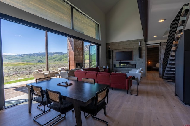 470 White Stallion Cir, Crested Butte, CO 81224 - dining space featuring a fireplace, a mountain view, wood finished floors, a towering ceiling, and stairs