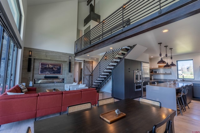 470 White Stallion Cir, Crested Butte, CO 81224 - dining room featuring light wood-style floors, stairs, a high ceiling, and recessed lighting