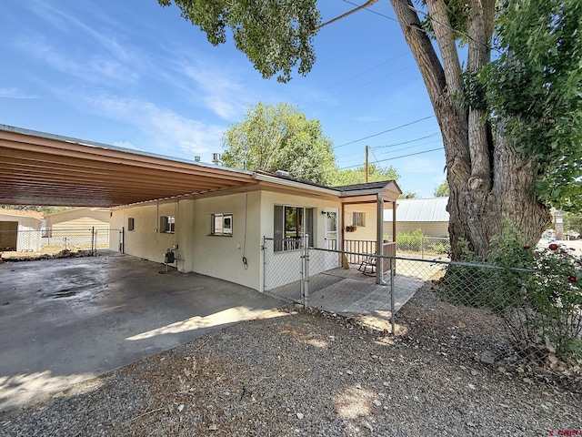 135 N 4th St, Hotchkiss, CO 81419 - view of home's exterior with a gate, stucco siding, and a carport
