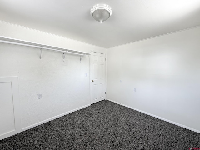 135 N 4th St, Hotchkiss, CO 81419 - unfurnished bedroom with dark carpet and baseboards