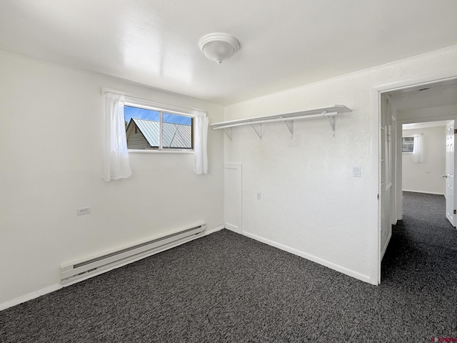 135 N 4th St, Hotchkiss, CO 81419 - spare room with a baseboard heating unit, dark colored carpet, and baseboards