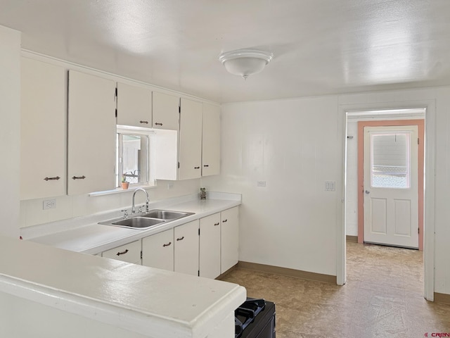 135 N 4th St, Hotchkiss, CO 81419 - kitchen featuring a sink, light countertops, white cabinets, and baseboards