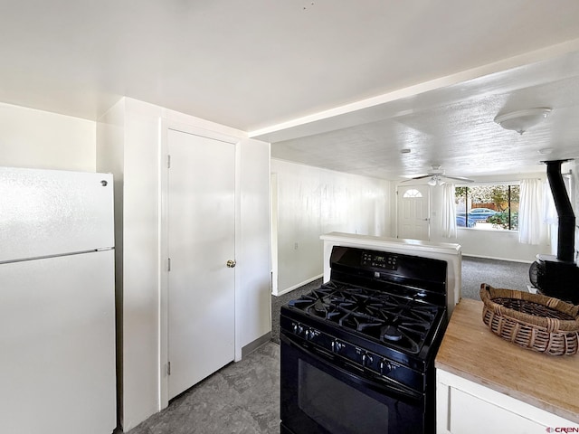 135 N 4th St, Hotchkiss, CO 81419 - kitchen with freestanding refrigerator, black gas stove, ceiling fan, and light countertops