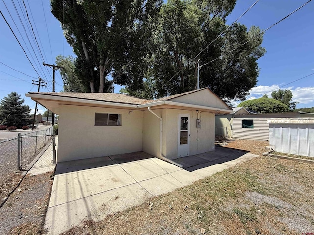 135 N 4th St, Hotchkiss, CO 81419 - rear view of property with stucco siding, a gate, and a patio
