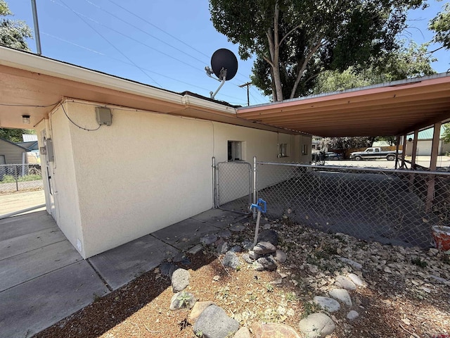 135 N 4th St, Hotchkiss, CO 81419 - view of property exterior with stucco siding and a gate