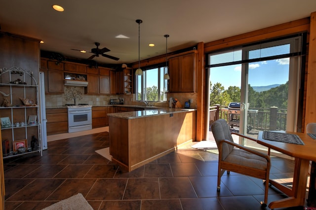 76 Pinnacle Dr, Ridgway, CO 81432 - kitchen with white gas range, under cabinet range hood, a peninsula, open shelves, and backsplash