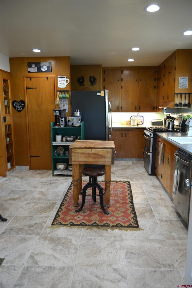 8801 2100th Rd, Austin, CO 81410 - kitchen with a sink, appliances with stainless steel finishes, brown cabinets, recessed lighting, and light countertops