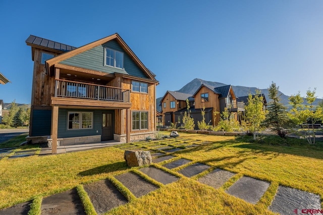 918 Belleview Ave, Crested Butte, CO 81224 - back of house with a balcony, a yard, a standing seam roof, and metal roof