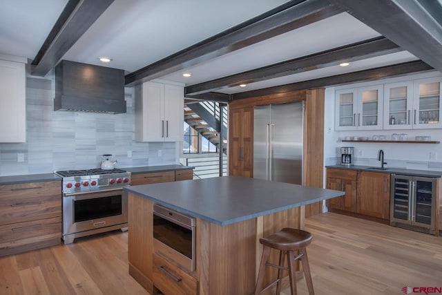 918 Belleview Ave, Crested Butte, CO 81224 - kitchen with high end appliances, wine cooler, custom range hood, beam ceiling, and a sink