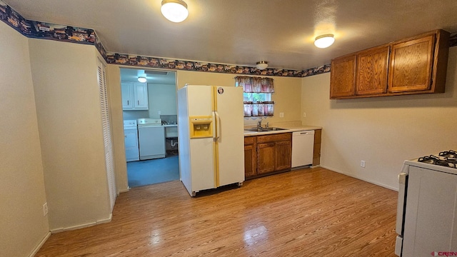 1551 G86 Rd, Delta, CO 81416 - kitchen with white appliances, a sink, light wood finished floors, and brown cabinetry