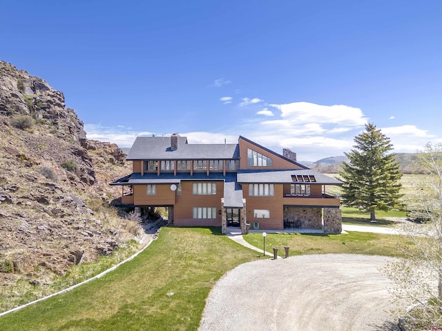 42246 US Highway 50, Gunnison, CO 81230 - rear view of house with dirt driveway, a chimney, a yard, and a balcony