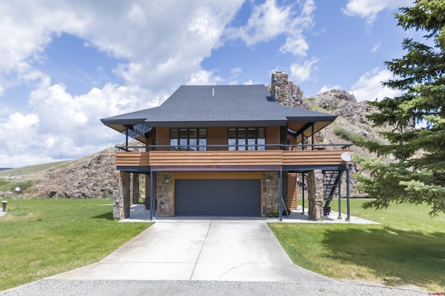 42246 US Highway 50, Gunnison, CO 81230 - view of front of home with a front yard, stone siding, driveway, a garage, and stairway