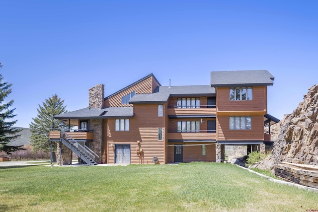 42246 US Highway 50, Gunnison, CO 81230 - back of property with a balcony, a yard, a chimney, stairs, and roof with shingles