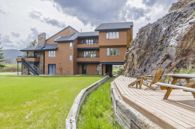 42246 US Highway 50, Gunnison, CO 81230 - back of house featuring a lawn, stairway, a chimney, a deck with mountain view, and a balcony