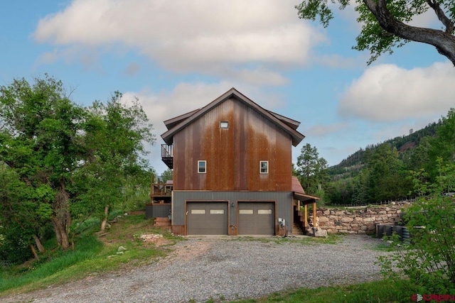 280 Marys Rd, Ridgway, CO 81432 - view of home's exterior featuring a balcony, a garage, and gravel driveway