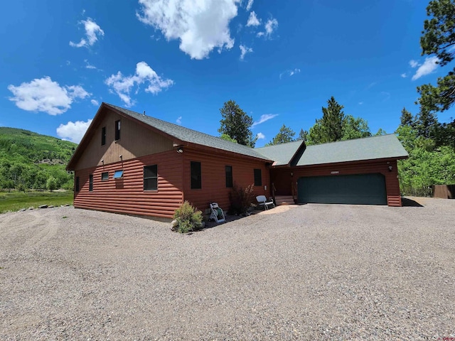 421 Elk Meadow Run, Antonito, CO 81120 - view of front of home featuring a garage, gravel driveway, and faux log siding