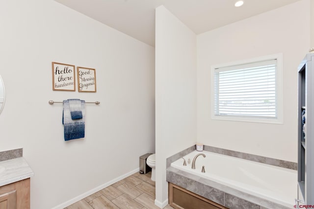 729 Spotted Pony Ct, Delta, CO 81416 - bathroom with vanity, toilet, a garden tub, wood finished floors, and baseboards