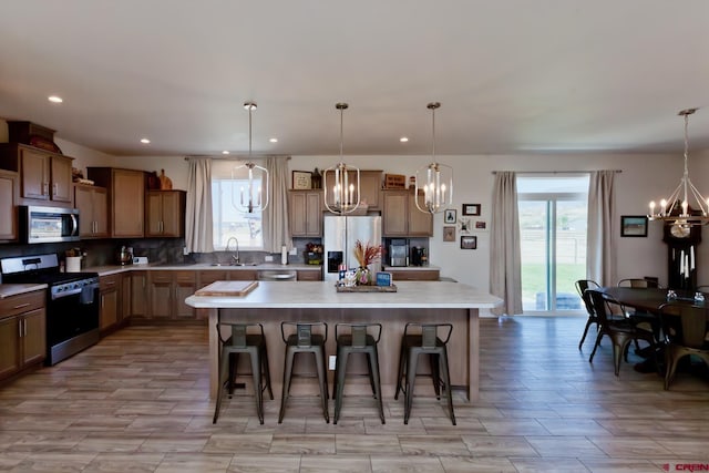 729 Spotted Pony Ct, Delta, CO 81416 - kitchen featuring stainless steel appliances, a chandelier, a sink, a kitchen breakfast bar, and a large island