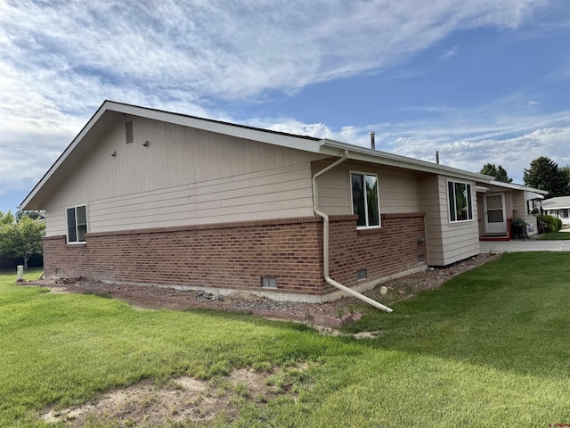 2149 Hartord Way Unit A, Montrose, CO 81401 - view of home's exterior featuring brick siding and a yard