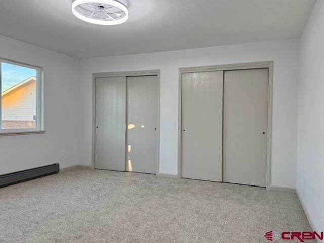 2149 Hartord Way Unit A, Montrose, CO 81401 - unfurnished bedroom with multiple closets, a baseboard radiator, carpet, and baseboards
