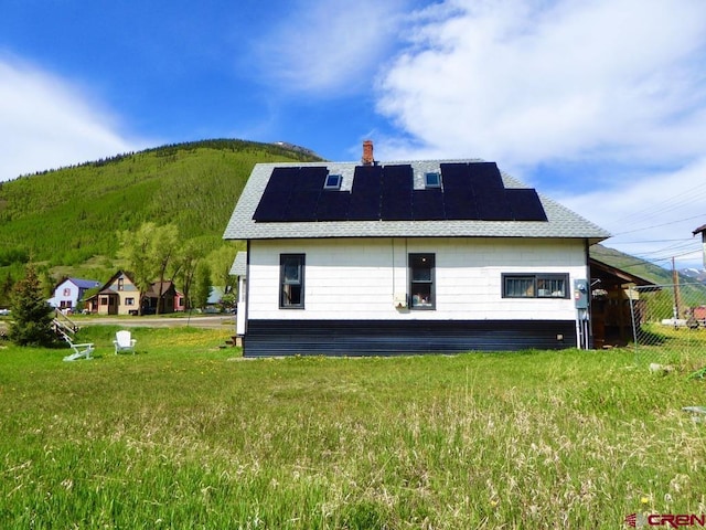 1572 Greene St, Silverton, CO 81433 - back of house featuring roof mounted solar panels, a chimney, a mountain view, and a shingled roof