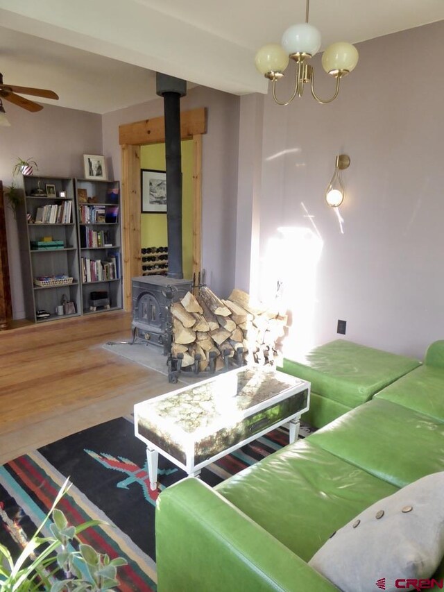 1572 Greene St, Silverton, CO 81433 - living room with a wood stove, ceiling fan, wood finished floors, and a chandelier
