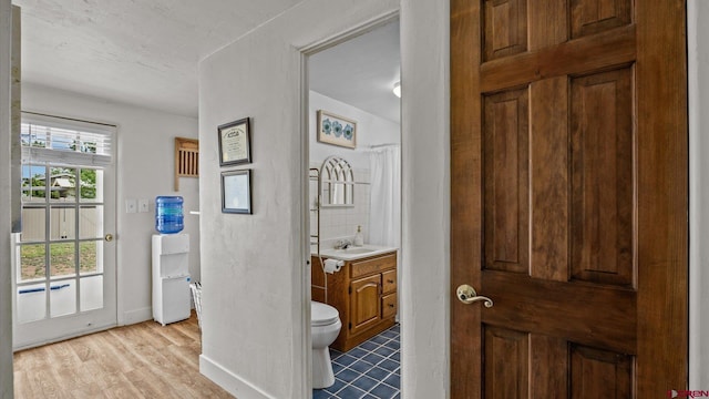 355 NW 5th St, Cedaredge, CO 81413 - full bath with toilet, vanity, wood finished floors, baseboards, and a shower with curtain