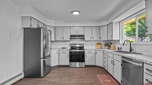 2130 Hartford Way Unit C, Montrose, CO 81401 - kitchen with stainless steel appliances, under cabinet range hood, a baseboard radiator, backsplash, and light countertops