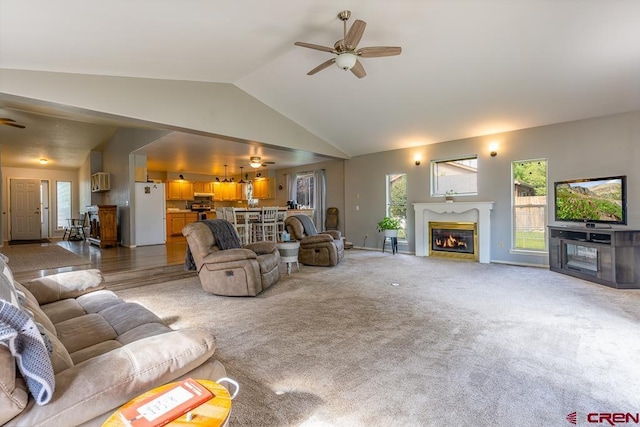 345 Meadows Cir, Bayfield, CO 81122 - carpeted living room featuring a ceiling fan, a glass covered fireplace, and high vaulted ceiling