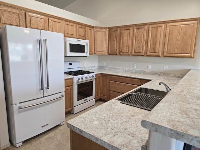 1285 Peppertree Dr, Montrose, CO 81401 - kitchen featuring white appliances, brown cabinetry, light countertops, and a peninsula