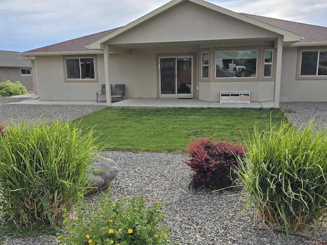1285 Peppertree Dr, Montrose, CO 81401 - back of property with stucco siding, a patio area, a lawn, and a shingled roof