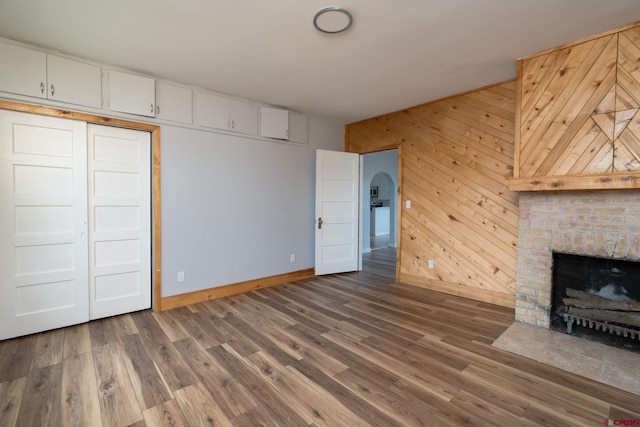 6038 Townsend Rd, Delta, CO 81416 - unfurnished living room featuring a fireplace with flush hearth, wood finished floors, and wood walls